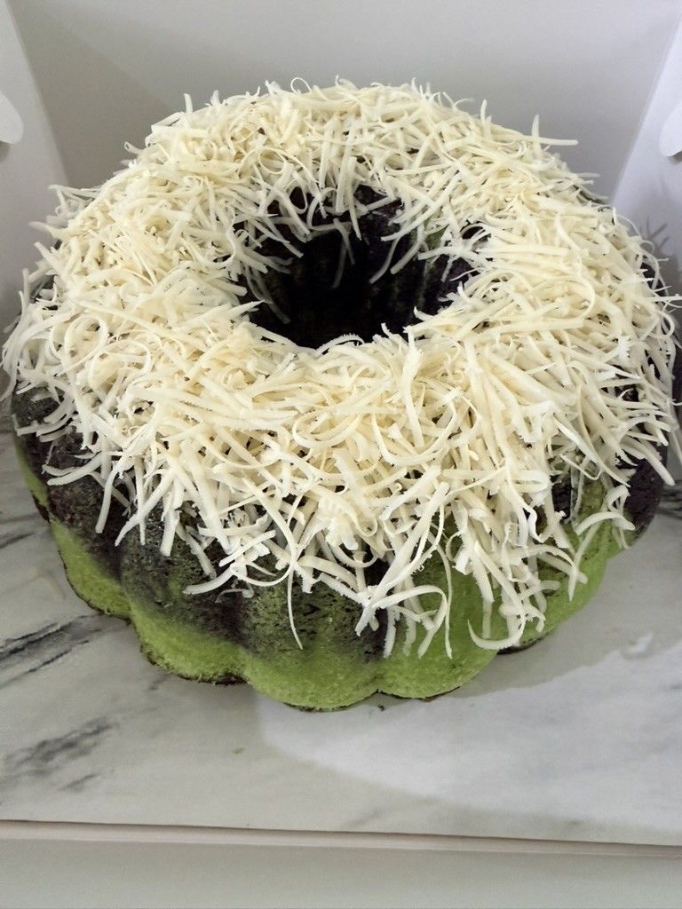 Bolu Kukus Ketan Hitam Pandan berlapis hijau dan hitam di atas alas marmer, kue faiha.id untuk snack time di kantor
